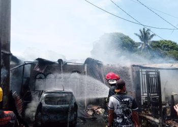 Rumah marga Silaban yang terbakar, tampak petugas sedang memadamkan api