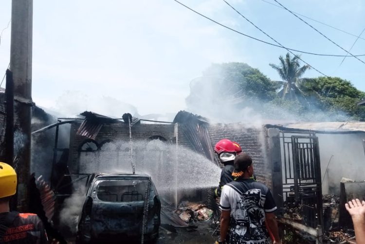 Rumah marga Silaban yang terbakar, tampak petugas sedang memadamkan api