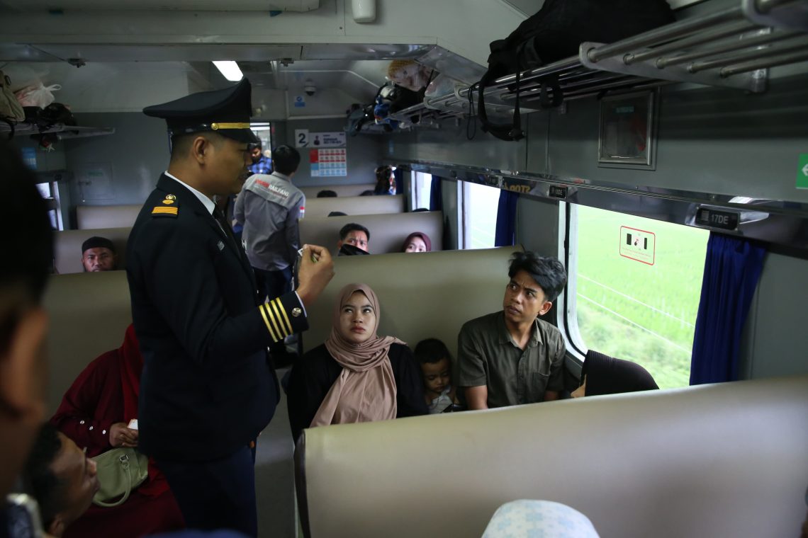 Petugas PT KAI saat menyampaikan arahan kepada para penumpang yang ada didalam Kereta Api.