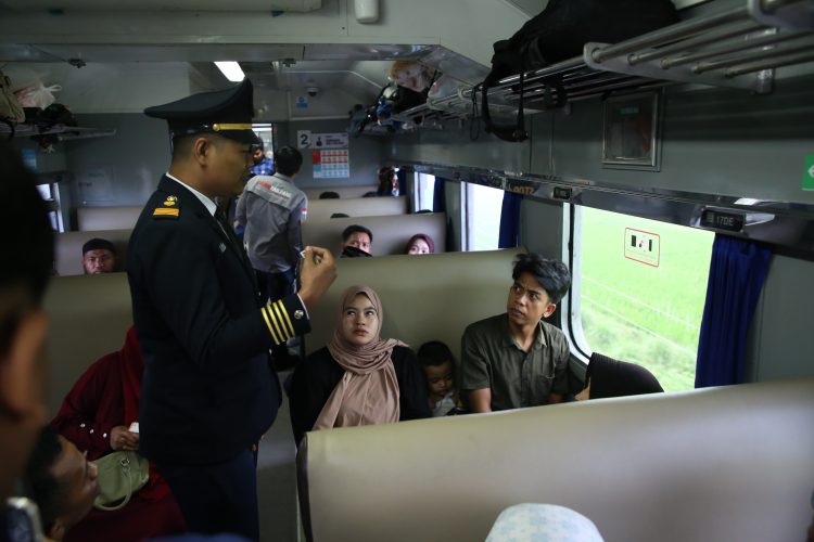Petugas PT KAI saat menyampaikan arahan kepada para penumpang yang ada didalam Kereta Api.