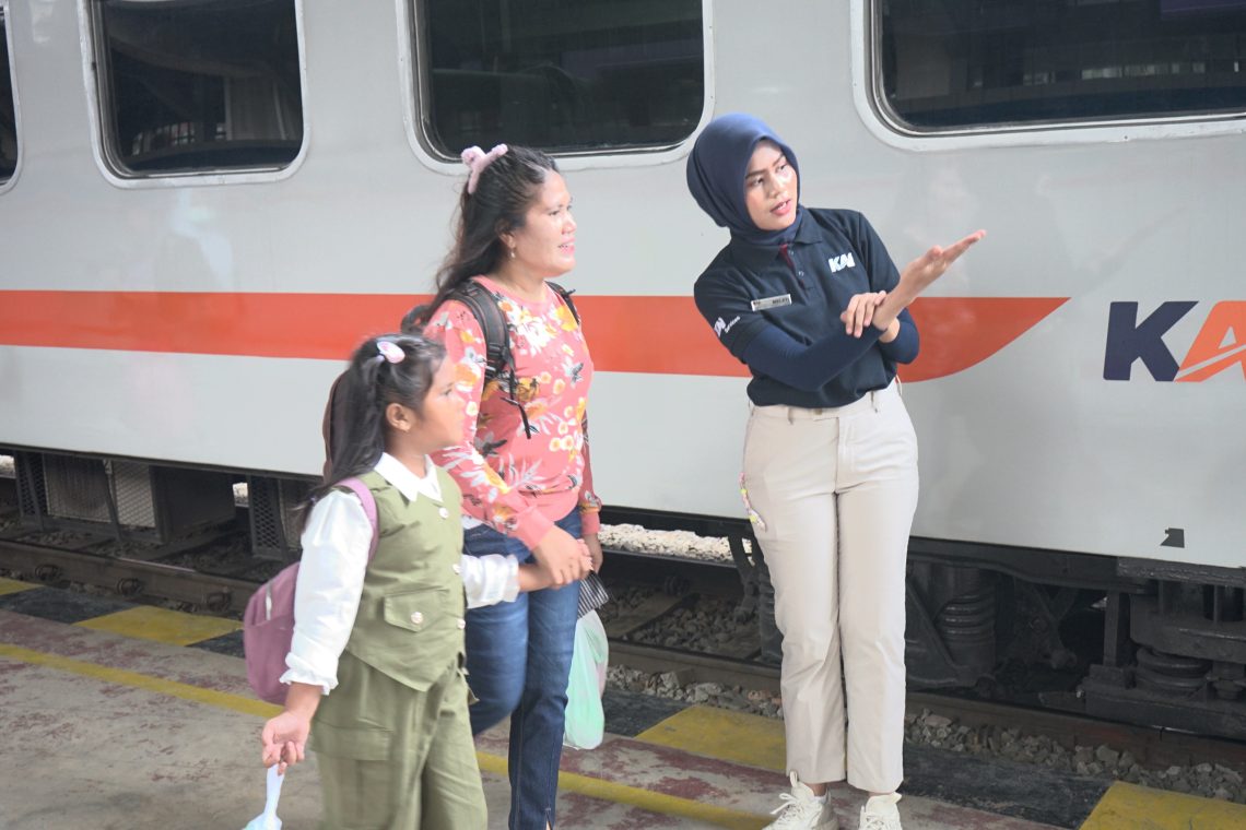 Petugas stasiun KA Medan saat memberikan arahan kepada penumpang.