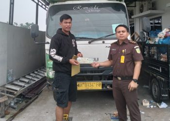 Serah terima barang lelangan antara pihak Kejari Simalungun dengan pemenang lelang.