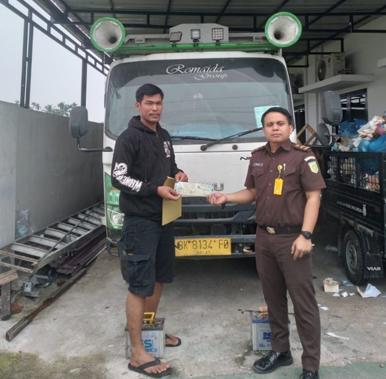 Serah terima barang lelangan antara pihak Kejari Simalungun dengan pemenang lelang.