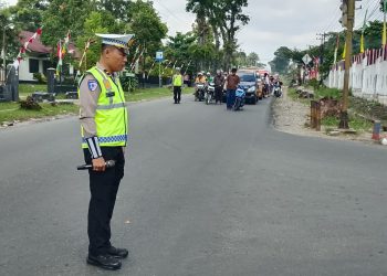 Personil Sat lantas Polres Simalungun saat hentikan pengendara yang melintas saat hening cipta HUT RI-81.