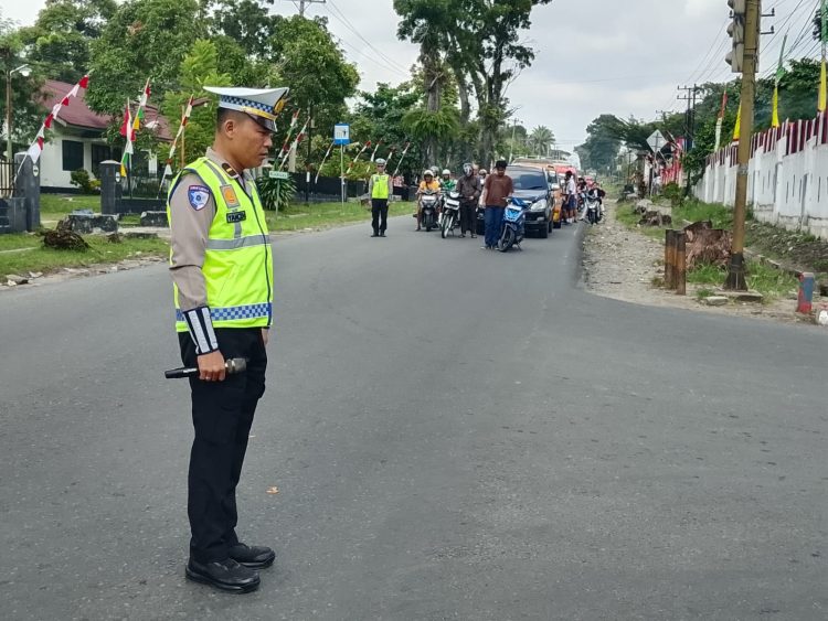 Personil Sat lantas Polres Simalungun saat hentikan pengendara yang melintas saat hening cipta HUT RI-81.