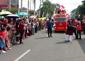 Masyarakat Kota Pematangsiantar saat menyaksikan karnaval melihat mobil yang dihiasi ( Herry Sinaga)