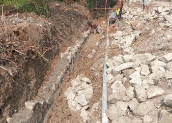 Kondisi saat pekerja memasang batu Padas, pada parit yang dalam keadaan berair dan berlumpur ( Herry Sinaga )