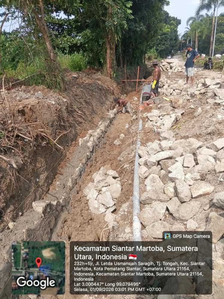 Kondisi saat pekerja memasang batu Padas, pada parit yang dalam keadaan berair dan berlumpur ( Herry Sinaga )