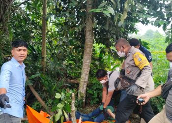 Personil Polsek Bandar Huluan saat mengevakuasi jenazah pria yang ditemukan tergantung di pohon melinjo ( Polsek Bandar Huluan )