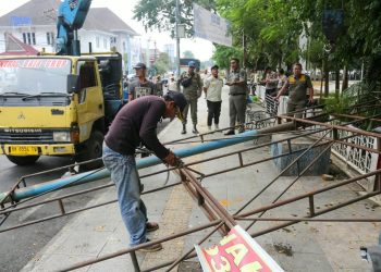 Petugas Satpol PP saat melakukan pembongkaran papan reklame yang tidak memiliki izin. ( Diskominfo Kota Pematangsiantar )