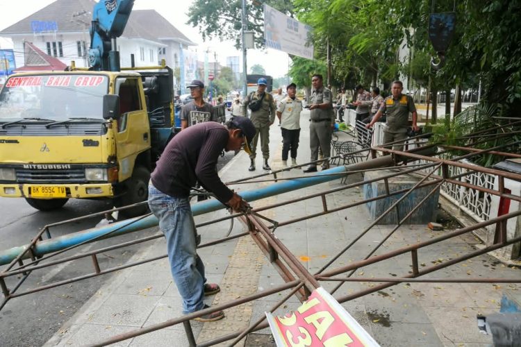 Petugas Satpol PP saat melakukan pembongkaran papan reklame yang tidak memiliki izin. ( Diskominfo Kota Pematangsiantar )
