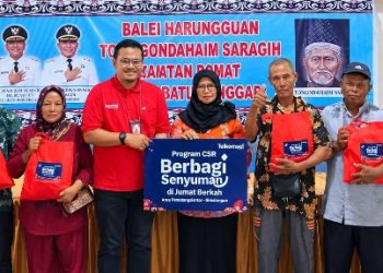 Pihak Telkomsel bersama Camat Dolok Batu Nanggar dan Warga saat memberikan sembako.( Herry Sinaga )